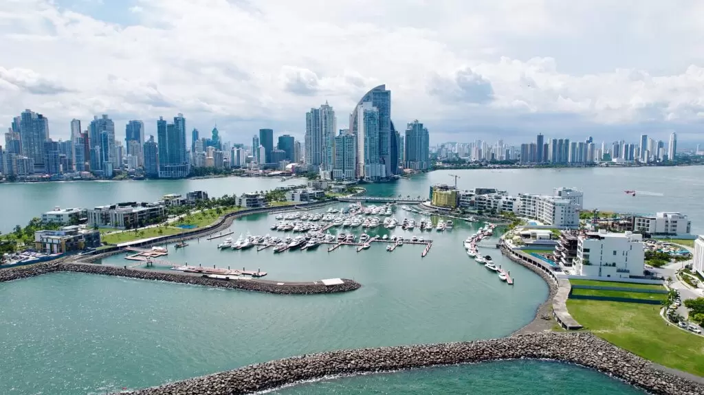Blick auf die moderne Skyline von Panama City mit zahlreichen Hochhäusern und Wolkenkratzern, davor eine Marina mit luxuriösen Yachten und Wohnanlagen direkt am Wasser.